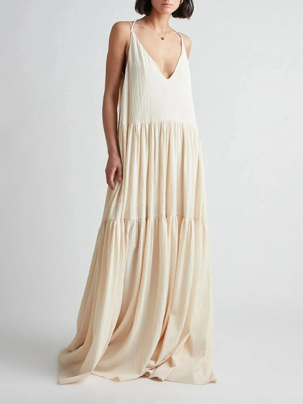 "Sand-colored V-neck maxi dress with tiered skirt showcasing a flowing design by Tinsley. Perfect for a casual yet elegant…