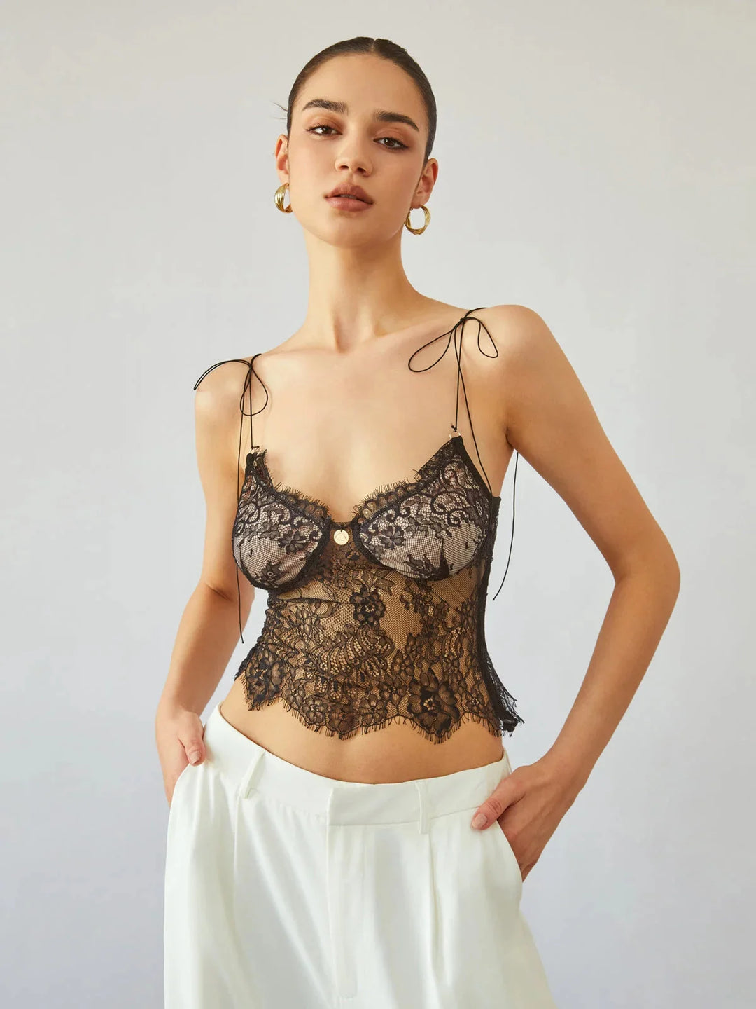 Black lace camisole top with adjustable straps, perfect for a chic and versatile look.
