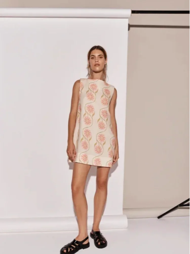 Pink floral A-Line sleeveless dress in Whitley, showcasing a vibrant floral pattern on a lightweight fabric with a…