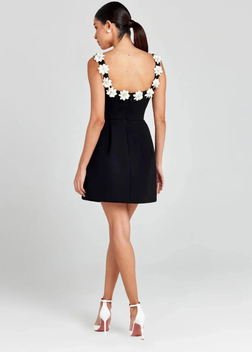 Black mini dress with white floral embroidery, perfect for a stylish look. Made with high-quality fabric and intricate…