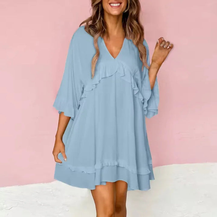 Blue flared V-neck dress with ruffle details, made of lightweight fabric perfect for any occasion.