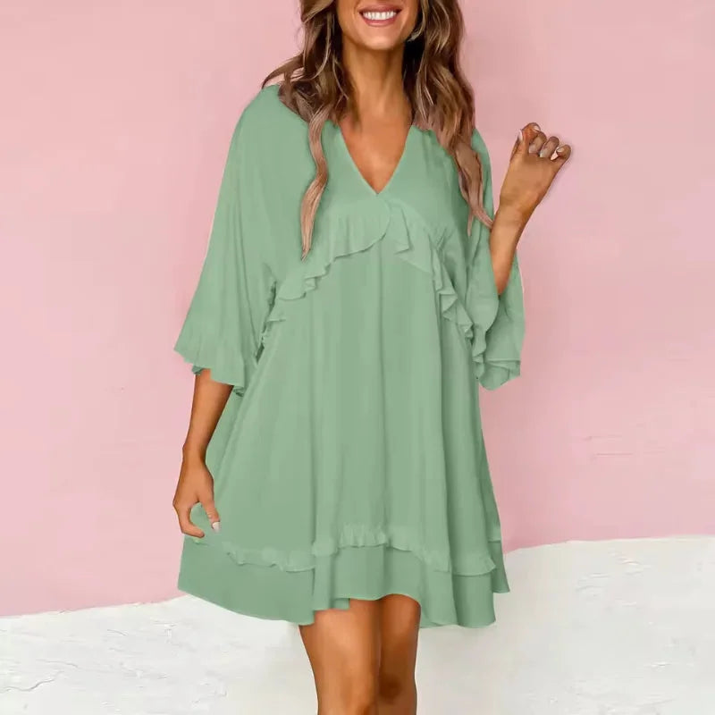 Green V-neck dress with ruffle details in a flared silhouette. Made of lightweight fabric, perfect for casual or formal…