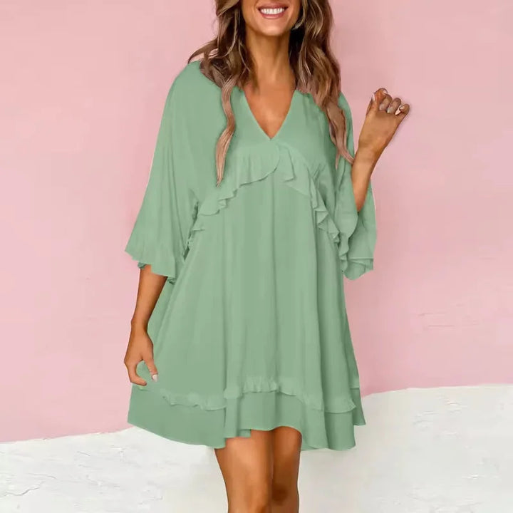 Green V-neck dress with ruffle details in a flared silhouette. Made of lightweight fabric, perfect for casual or formal…