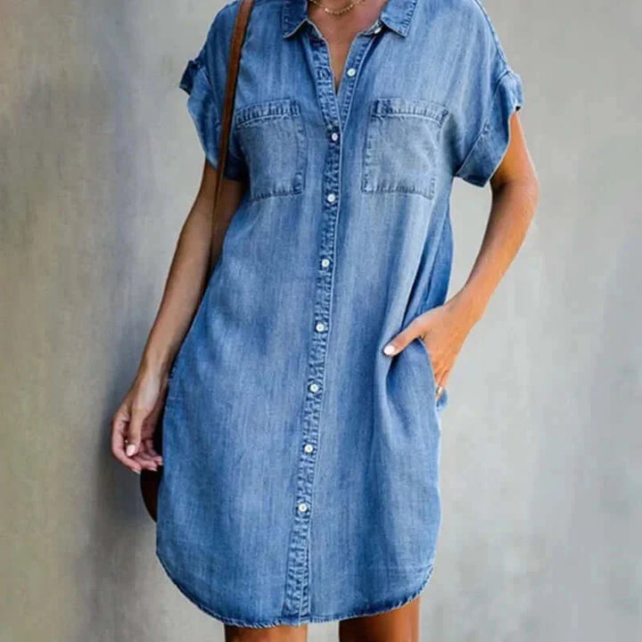 Light blue denim dress with button-front closure and pockets, ideal for a casual vintage-inspired look.