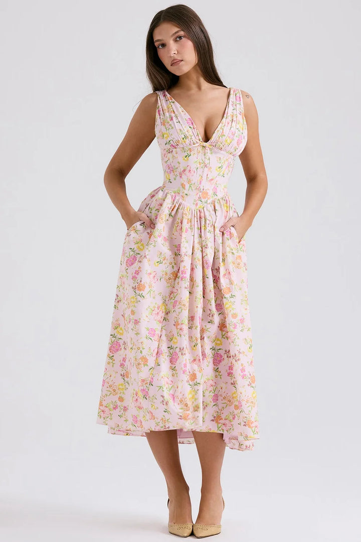 Pink floral midi dress with v-neckline by Nailani. Features a lightweight and flowy fabric perfect for a casual yet chic look.