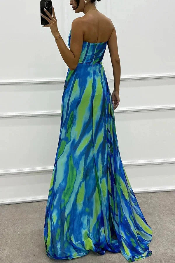 "Lilyanne maxi dress with side slit in striking floral print, perfect for summer days. Made of lightweight, flowy fabric."