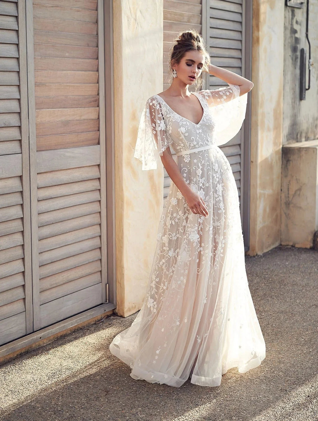 "White embroidered maxi dress with flutter sleeves, elegant design in airy fabric for a chic summer look by Lyric."