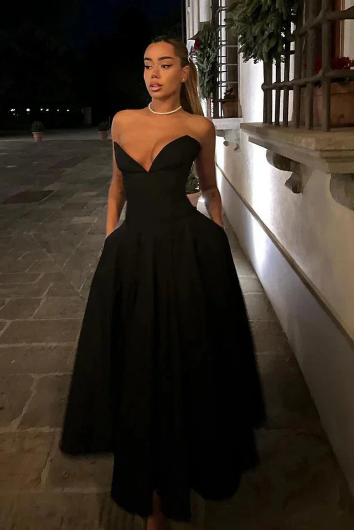 Black strapless corseted A-line midi dress by Camryn, made of satin fabric with lace-up detailing.