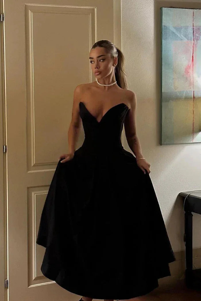 "Camryn strapless corseted A-line midi dress in sleek black satin fabric with sweetheart neckline and elegant silhouette."