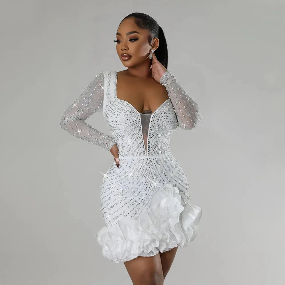 White mini dress with ruffles and embellishments by Cali. Lightweight material with intricate details.