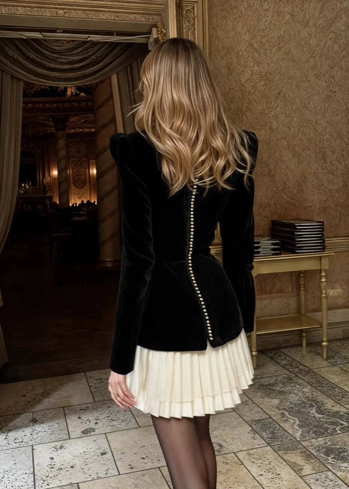 Black mini dress with contrasting bodice and pleated skirt by Janella. Detailed stitching and flattering silhouette.