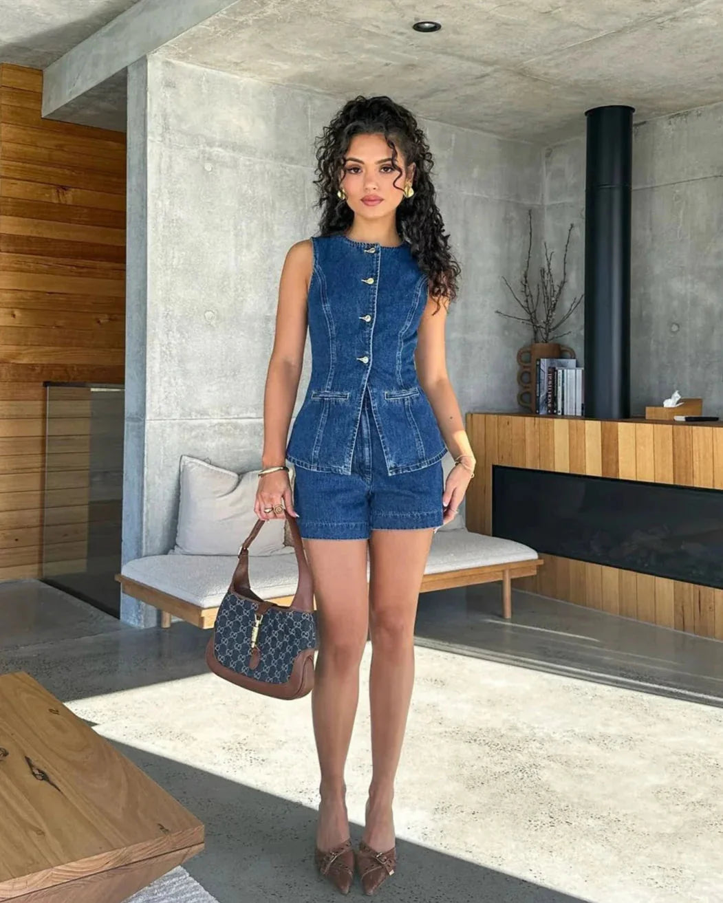 Sleeveless denim romper in Denim Blue with buttoned front, perfect for a casual yet stylish look.