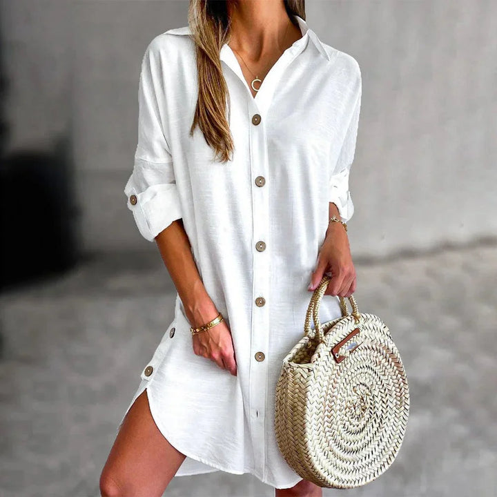 White mini dress featuring elegant button details, tailored design and soft fabric for a chic look.