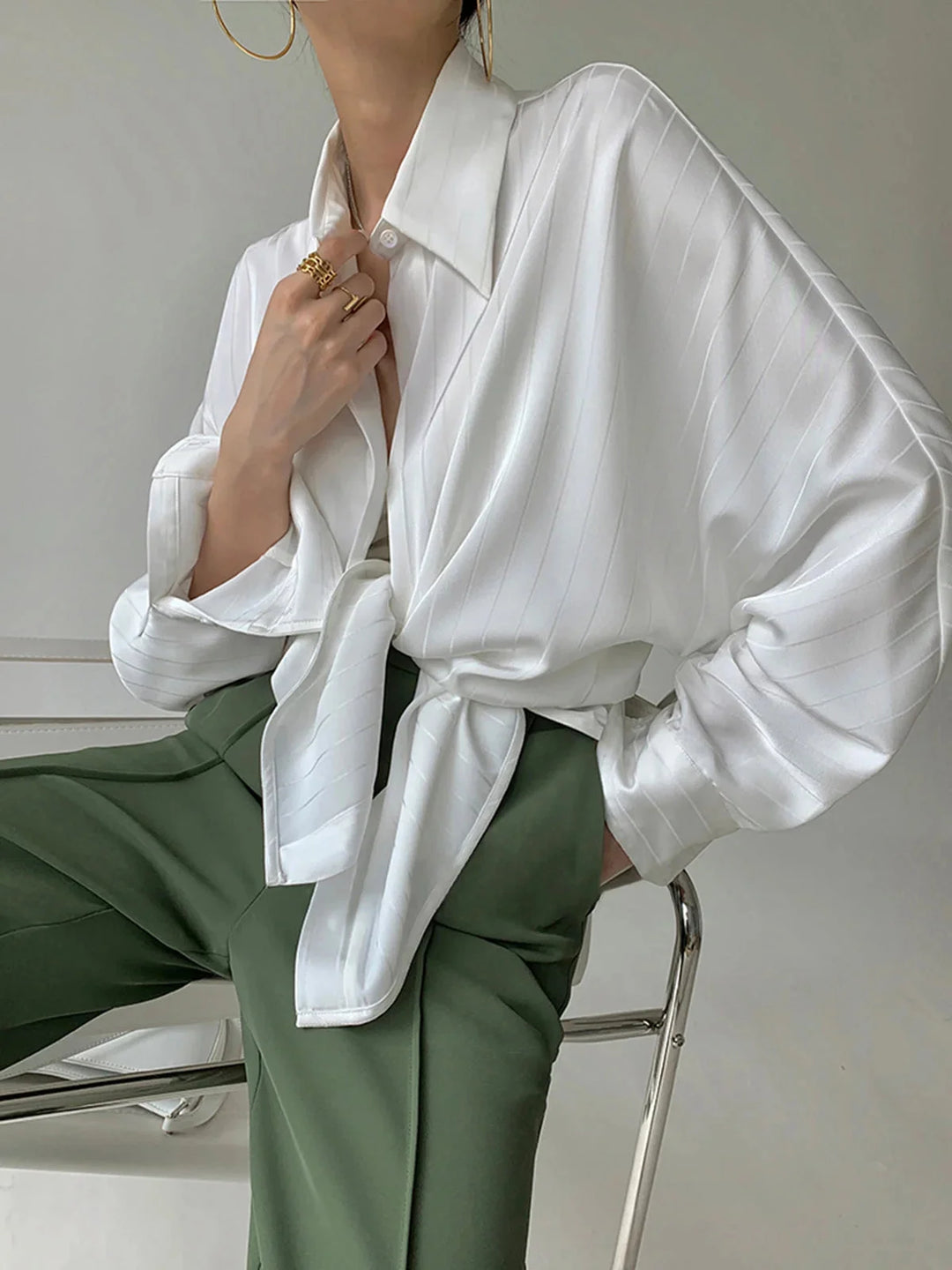 White Alaura button-up shirt with gold accents, elegantly tailored in a sleek design.