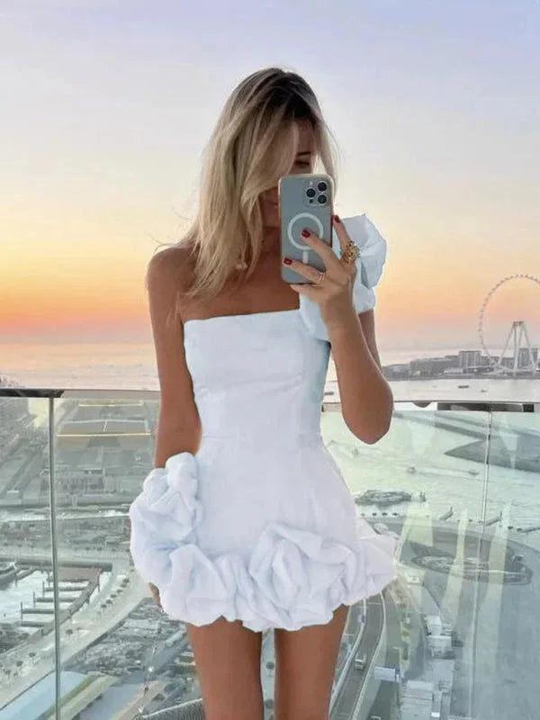 Off-shoulder mini dress in white with asymmetrical ruffles, perfect for a casual-chic look.