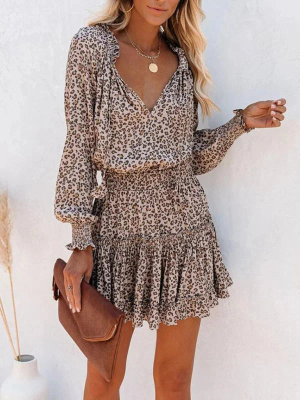 "Divisha black mini dress with V-neck and ruffle accents, perfect for a night out, made of soft and flowy fabric"