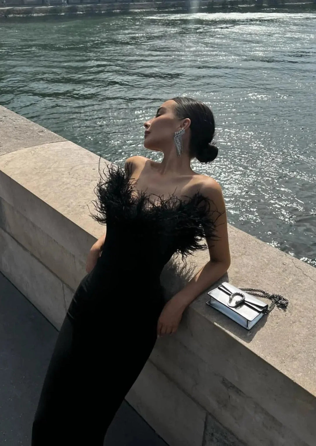 Black strapless dress with feather trim, perfect for a formal event. Made of high-quality fabric with a unique and elegant…