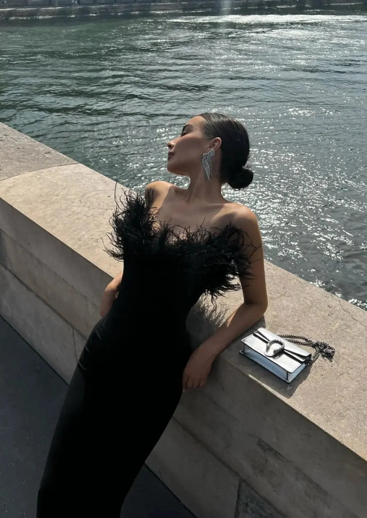 Black strapless dress with feather trim, perfect for a formal event. Made of high-quality fabric with a unique and elegant…