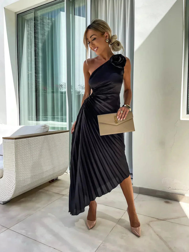 Black Lynlee one-shoulder pleated midi dress with a modern asymmetrical design and flowy silhouette, perfect for any…