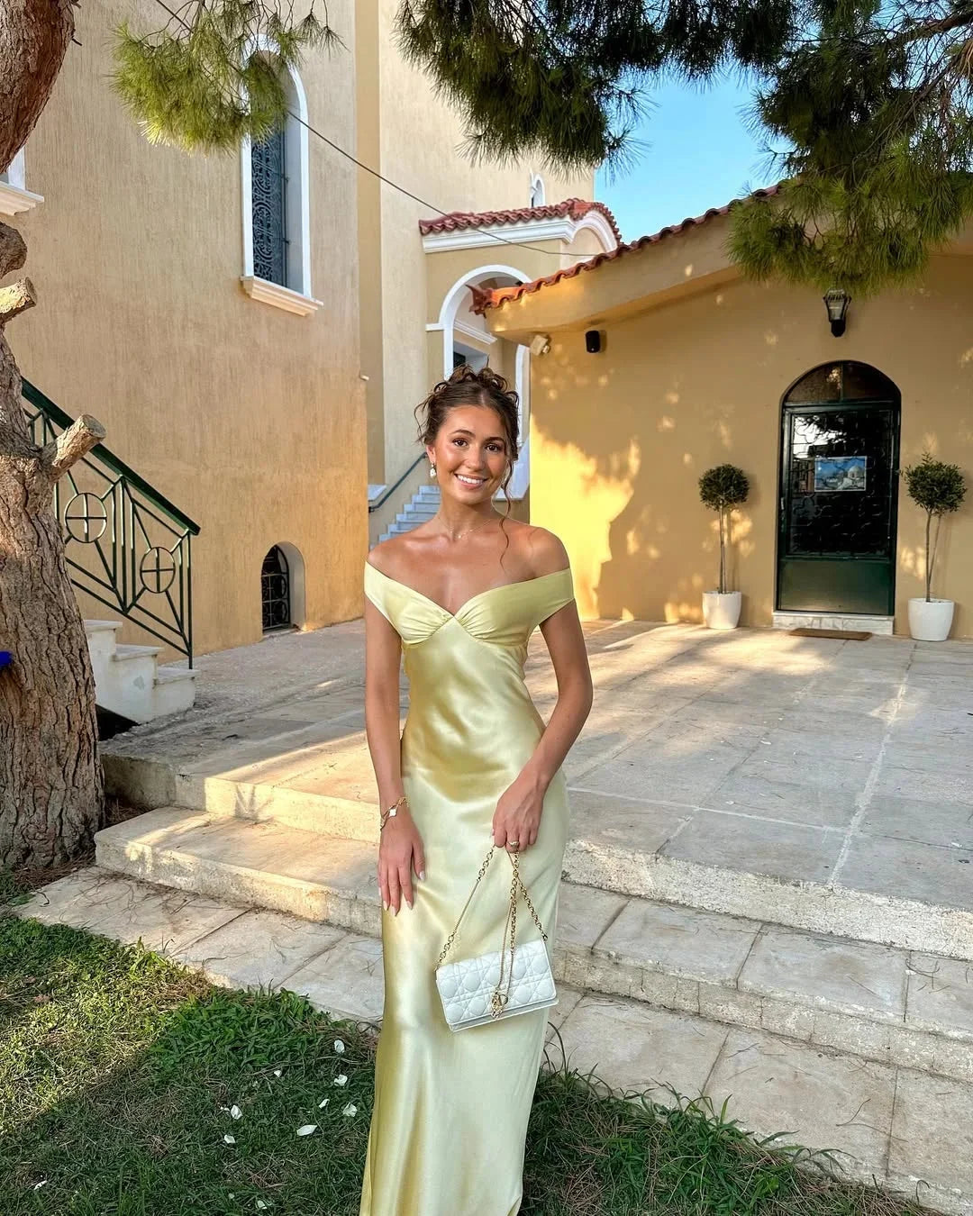 Cream off-shoulder maxi dress with clutch featuring Poppi design. Ideal for elegant occasions, made from quality material.