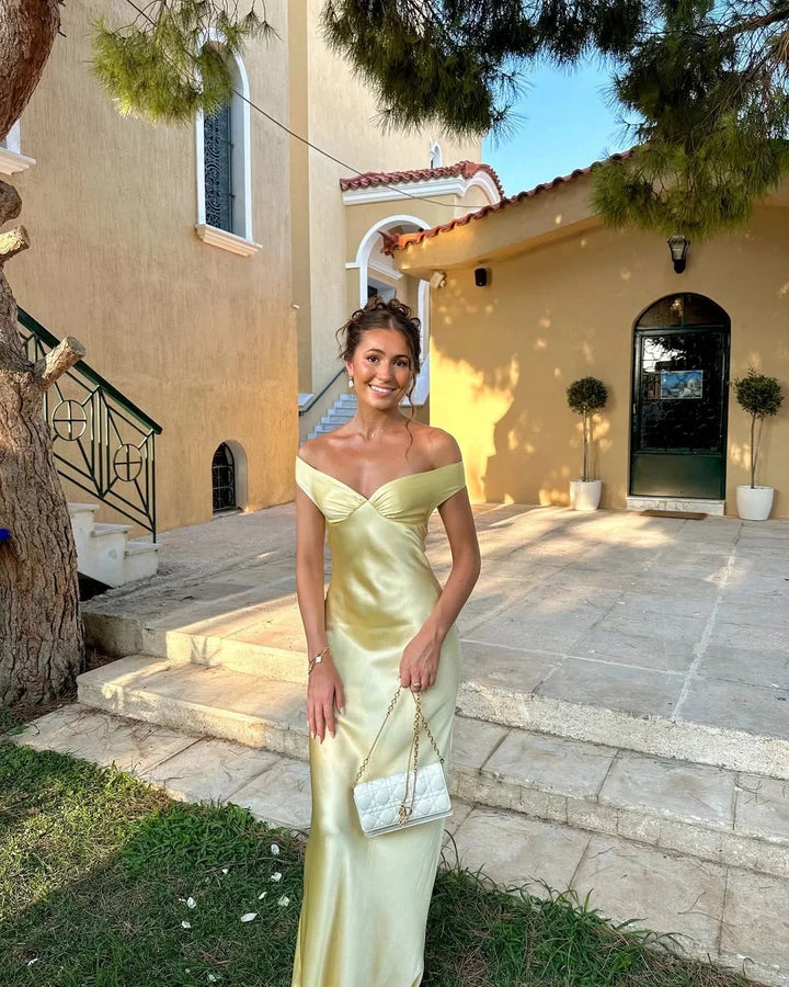 Cream off-shoulder maxi dress with clutch featuring Poppi design. Ideal for elegant occasions, made from quality material.