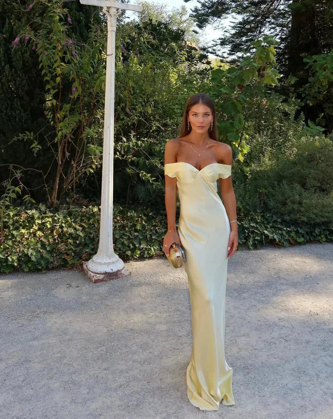 Cream off-shoulder maxi dress from Poppi, paired with matching clutch. Features a flowy silhouette in a soft, comfortable…