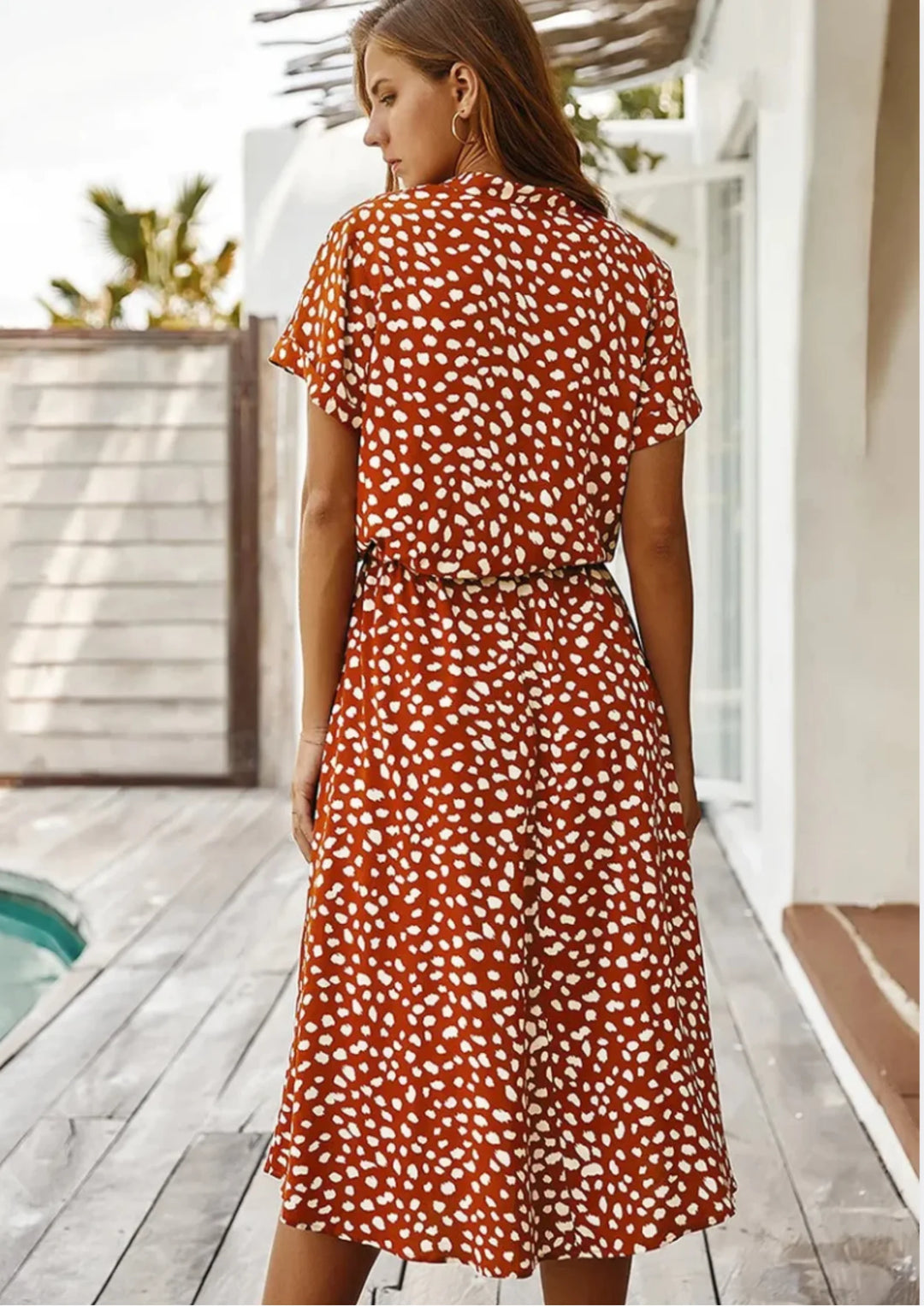 "Ximena polka dot dress with waist tie, mid-length and V-neck design, perfect for a chic and playful look."