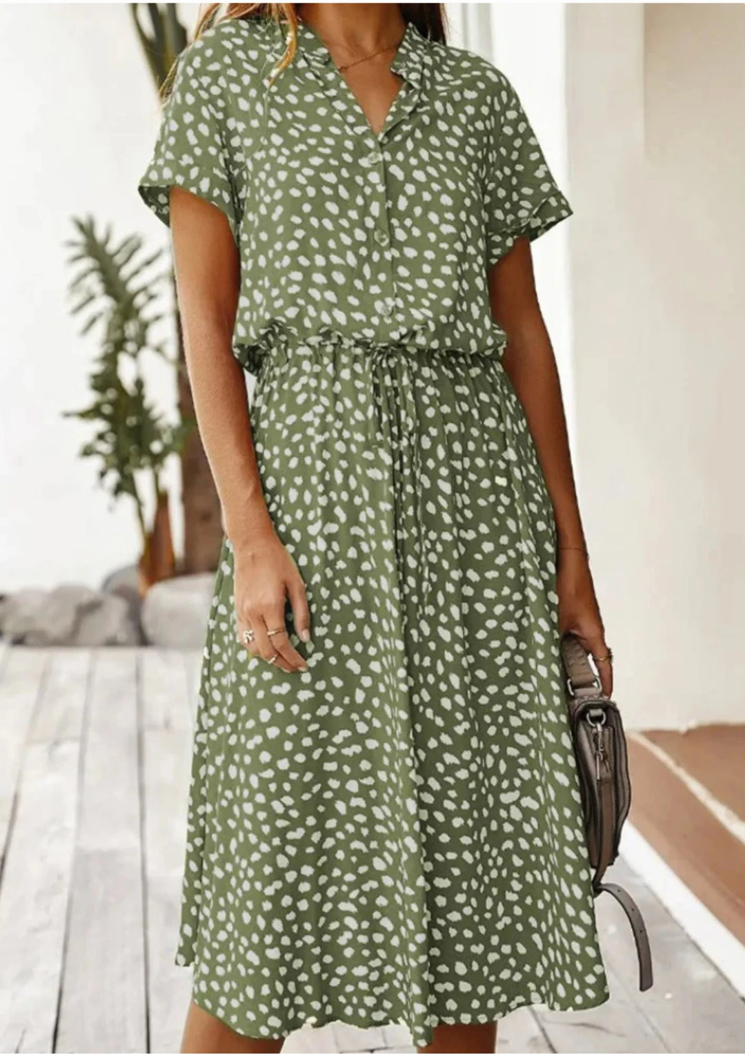 Ximena midi dress featuring polka dot pattern, waist tie, and knee-length cut in a comfortable fabric.