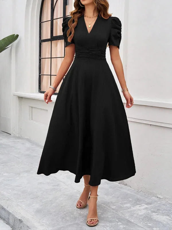 "Black midi dress with puff sleeves, V-neck, and flowy design."