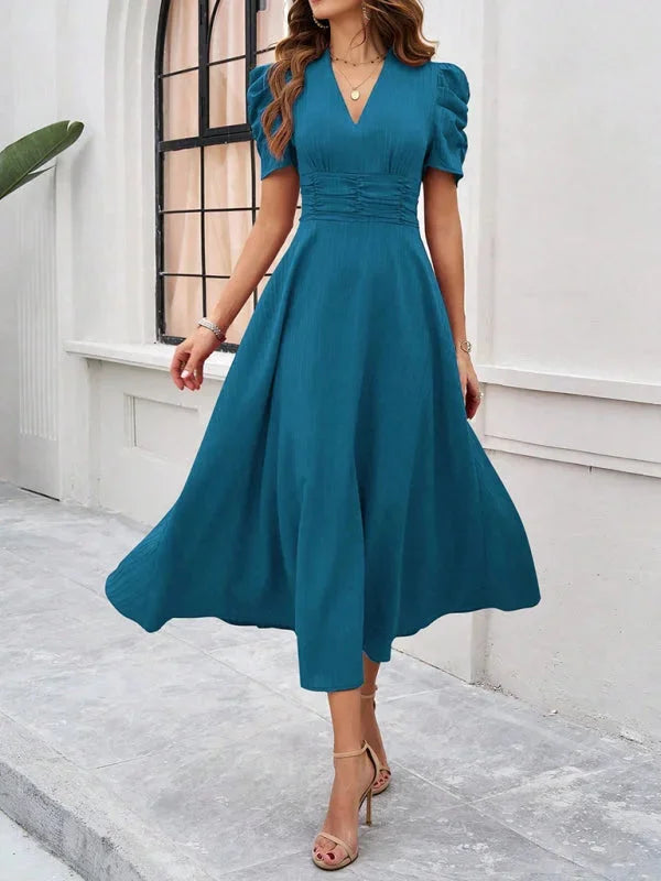 Blue flowy midi dress with puff sleeves and V-neck. Soft and breathable fabric perfect for a casual day out or special…