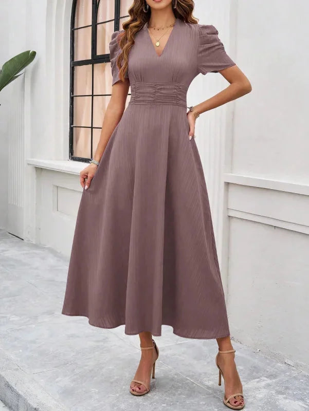 Brown flowy midi dress with puff sleeves and a V-neck design. Made from soft, lightweight fabric for a comfortable and…