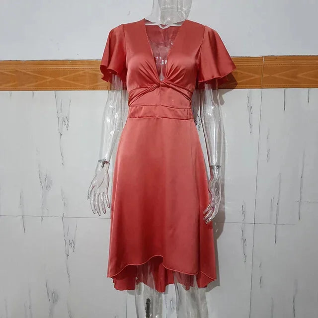 Asymmetric midi dress in Adela featuring flutter sleeves and a modern design perfect for casual or formal occasions.