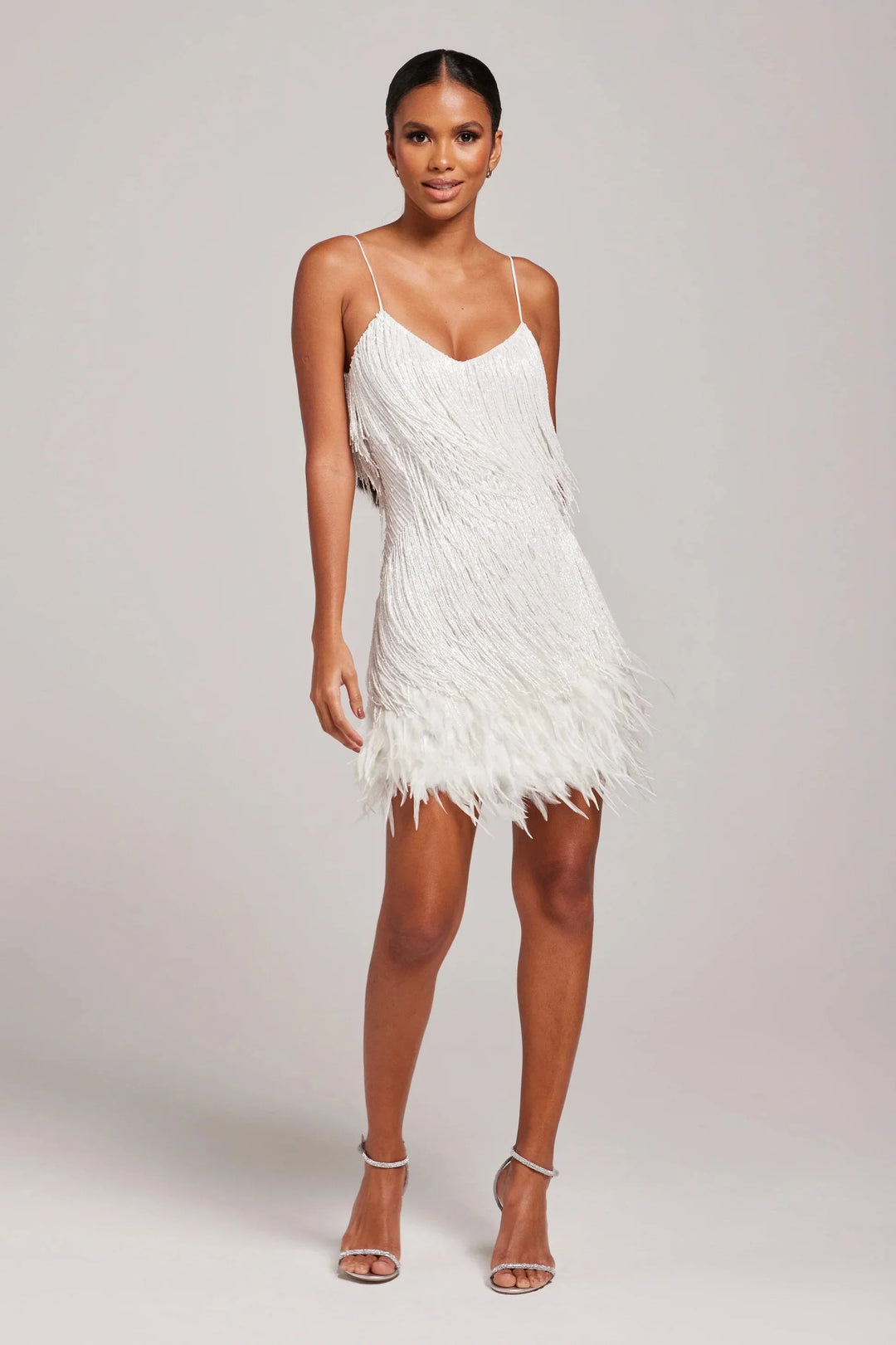 Black feathered mini dress with adjustable straps by Bostyn. Flattering design perfect for a night out or special occasion.