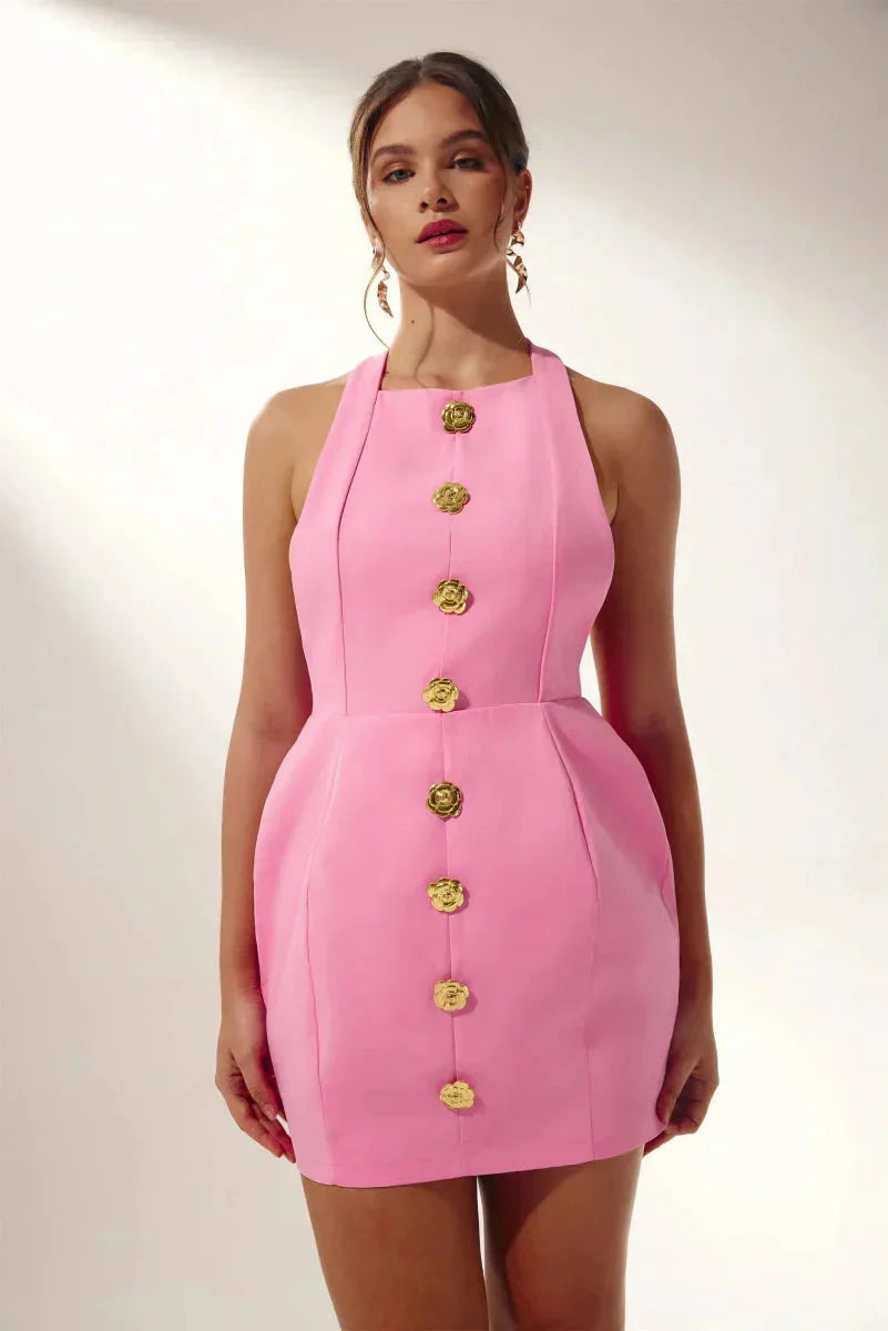Pink halter mini dress with delicate floral embellishments. Perfect for summer with a playful and trendy design.