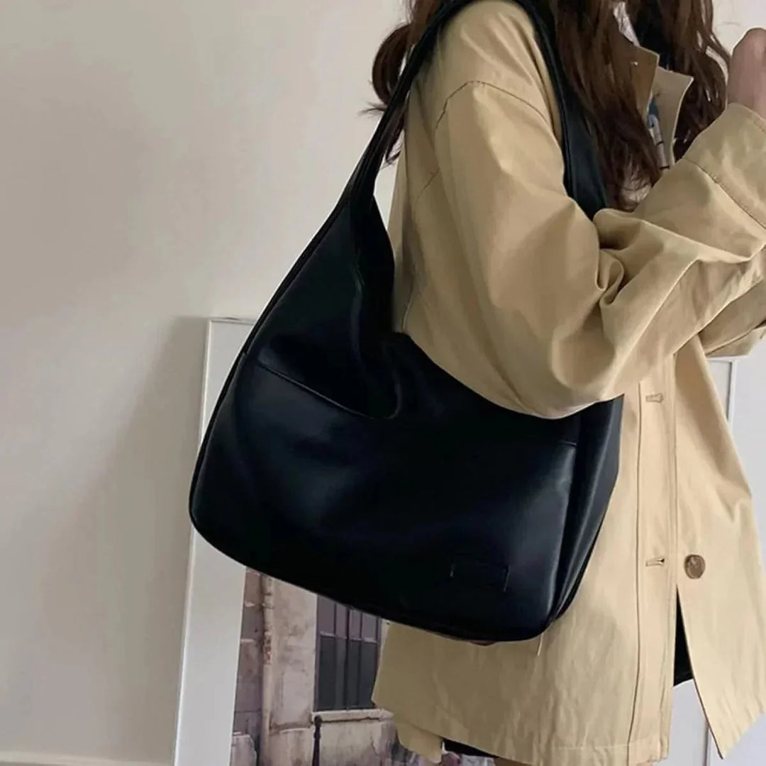 "Candy sleek modern shoulder bag in black leather with adjustable strap and magnetic closure"