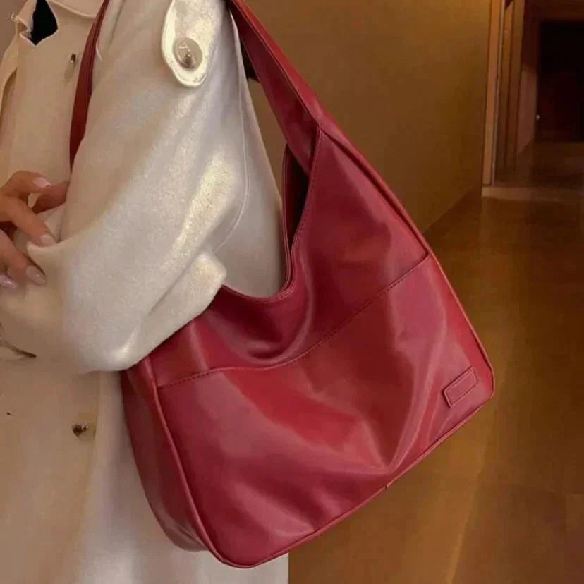 A sleek modern shoulder bag named Candy, made of durable faux leather with geometric stitching details and a concealed…