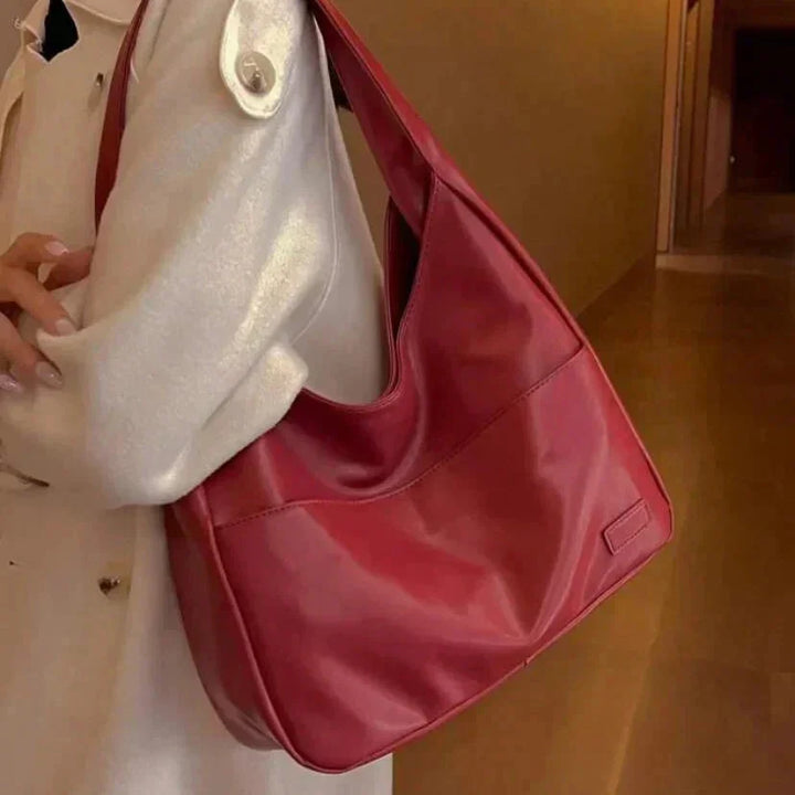 A sleek modern shoulder bag named Candy, made of durable faux leather with geometric stitching details and a concealed…