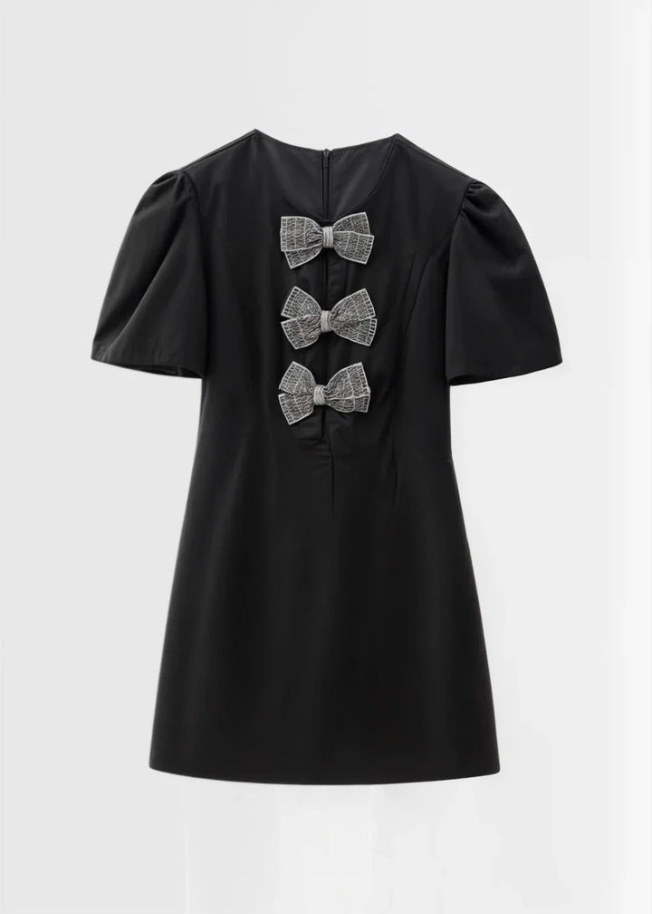 "Toby mini dress with puff sleeves and bows, made from soft and elegant fabric in a flattering A-line silhouette."