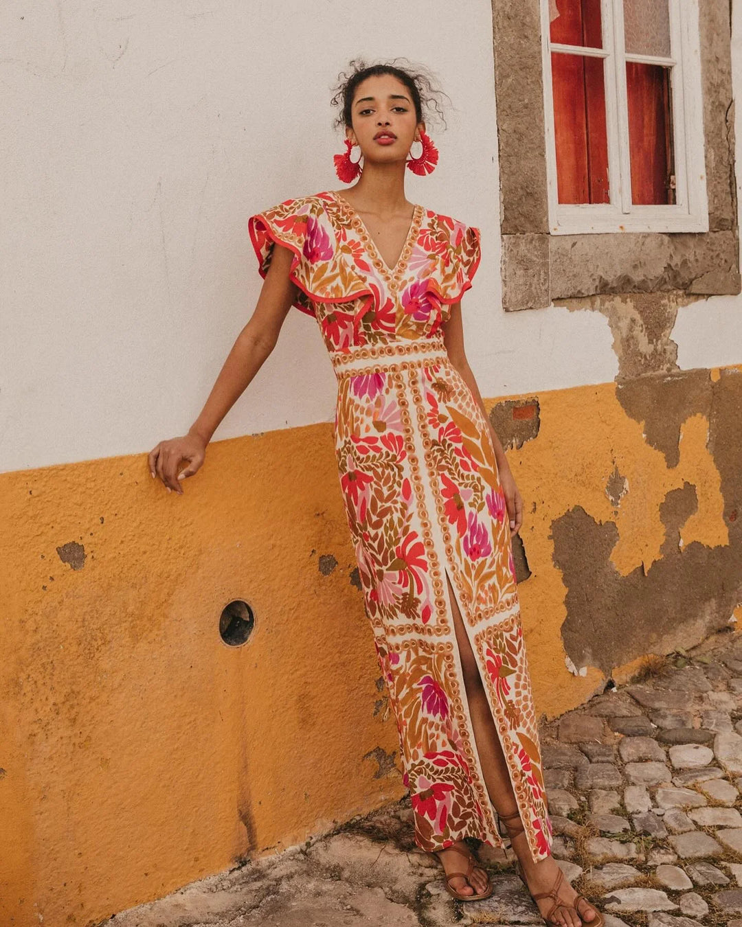 Red floral slit maxi dress for women by Raeleigh, featuring a lightweight fabric with a vibrant floral print and a stylish…