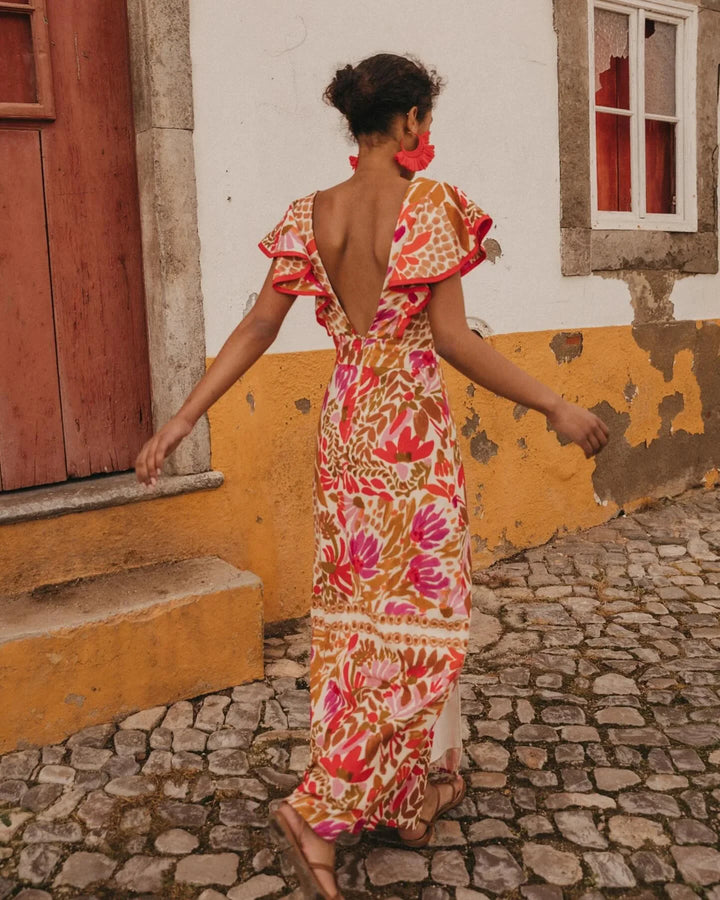 Red floral slit maxi dress for women by Raeleigh. Features a vibrant floral pattern, stylish slit, and flowing fabric for a…