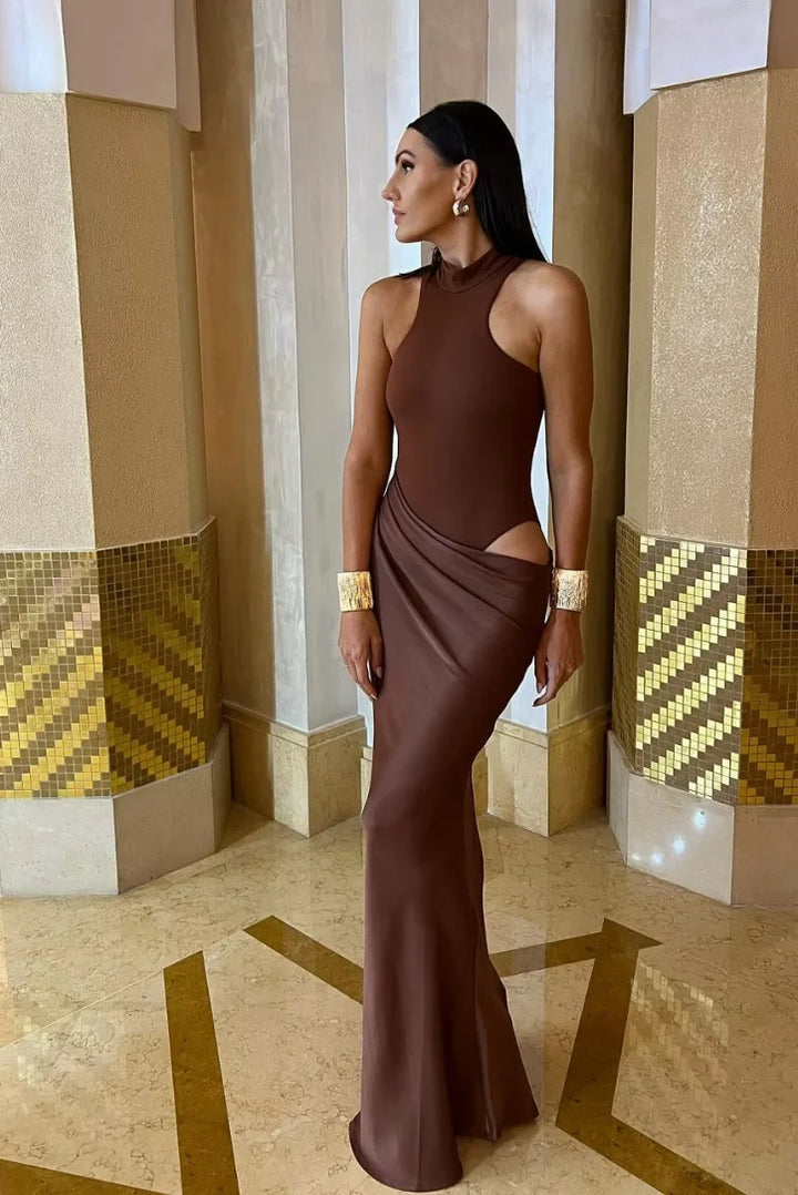 Black halter neck maxi dress with cut-outs at the waist, featuring a flowy and elegant design.