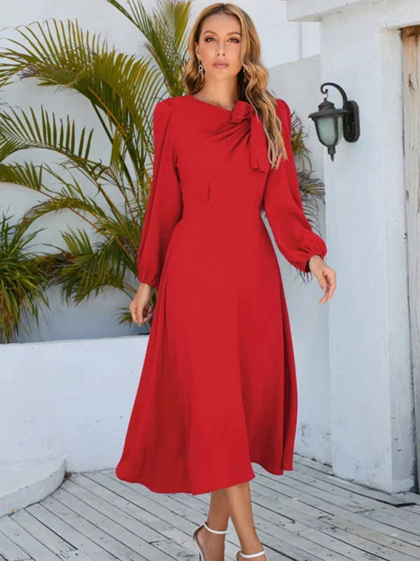 Flowy knee-length dress in Cambri with a delicate bow accent, perfect for a stylish and elegant look.