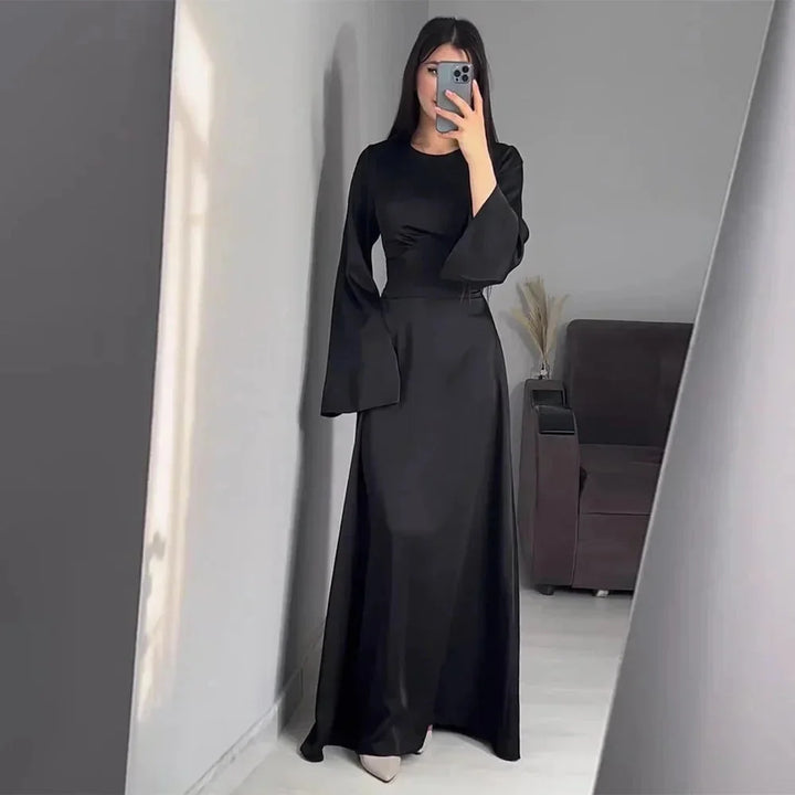"Black floor-length dress with bell sleeves, made of soft and flowing fabric, perfect for elegant occasions."