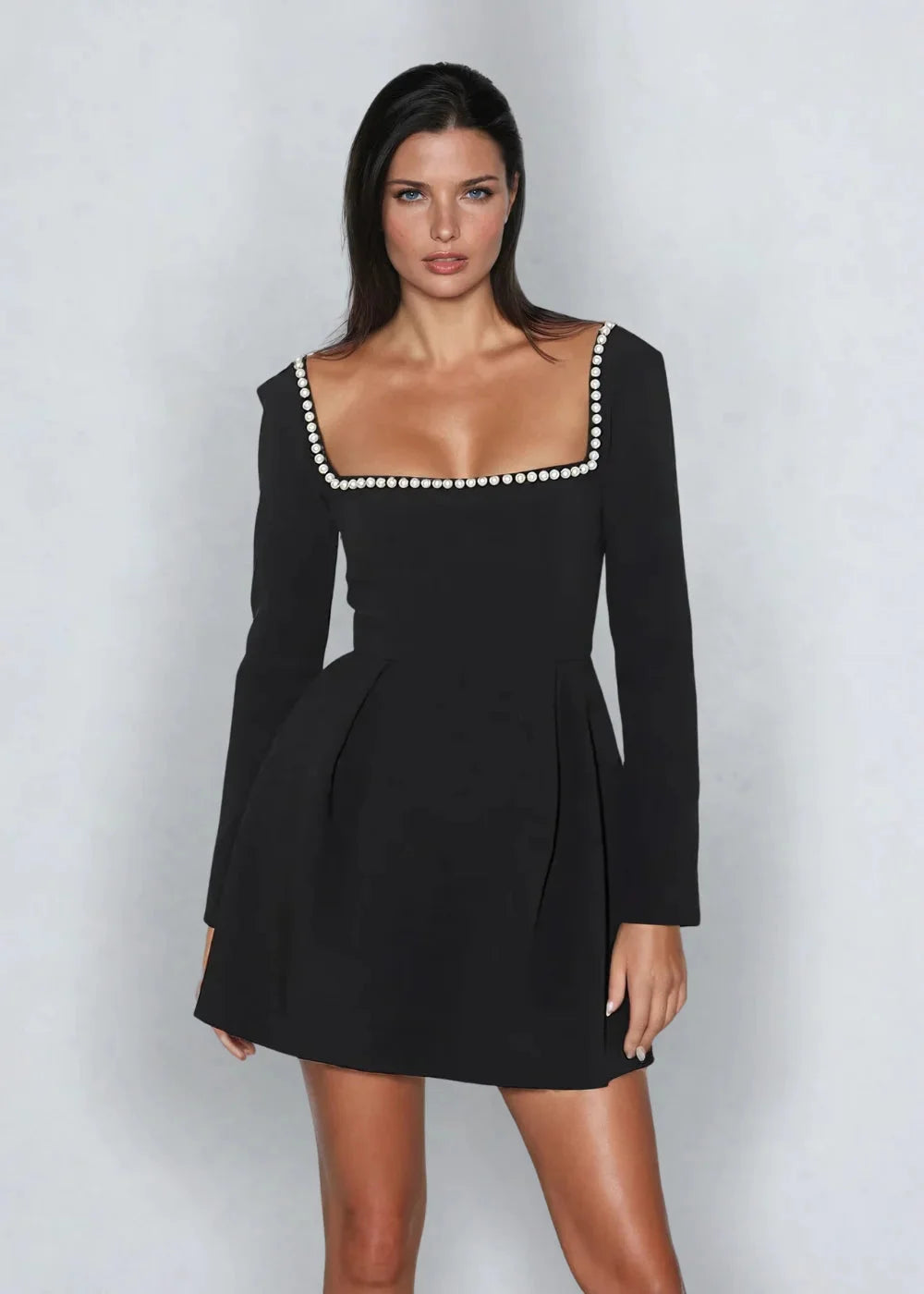 "Black mini dress with square neckline and bead detail, perfect for a versatile and elegant look."