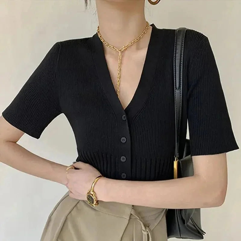 Black fitted knit cardigan with buttons by Talitha. Textured ribbed knit design, elegant silhouette, versatile styling for…