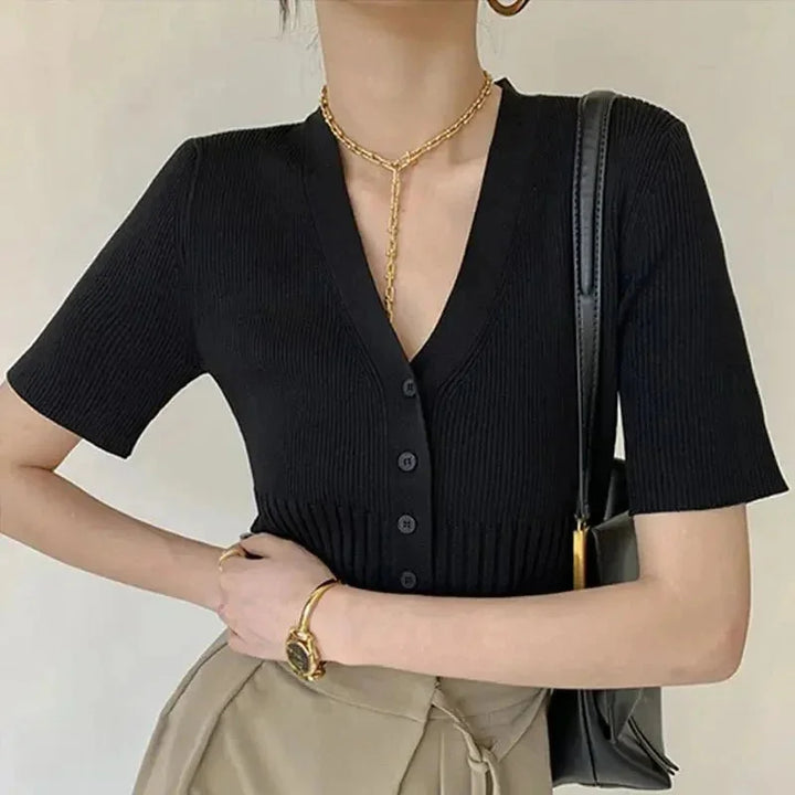 Black fitted knit cardigan with buttons by Talitha. Textured ribbed knit design, elegant silhouette, versatile styling for…