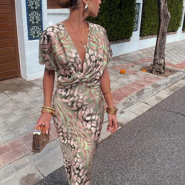 Green v-neck wrap dress with an elegant floral print design, made with soft and breathable fabric.