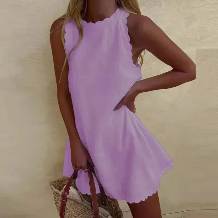 "Navy sleeveless dress with scalloped hem detailing, perfect for breezy summer days, made from soft cotton blend fabric."