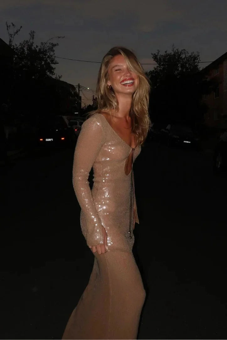 Beige sequined dress with long sleeves and deep V-neck showcasing elegant design with subtle shimmer for a glamorous look.