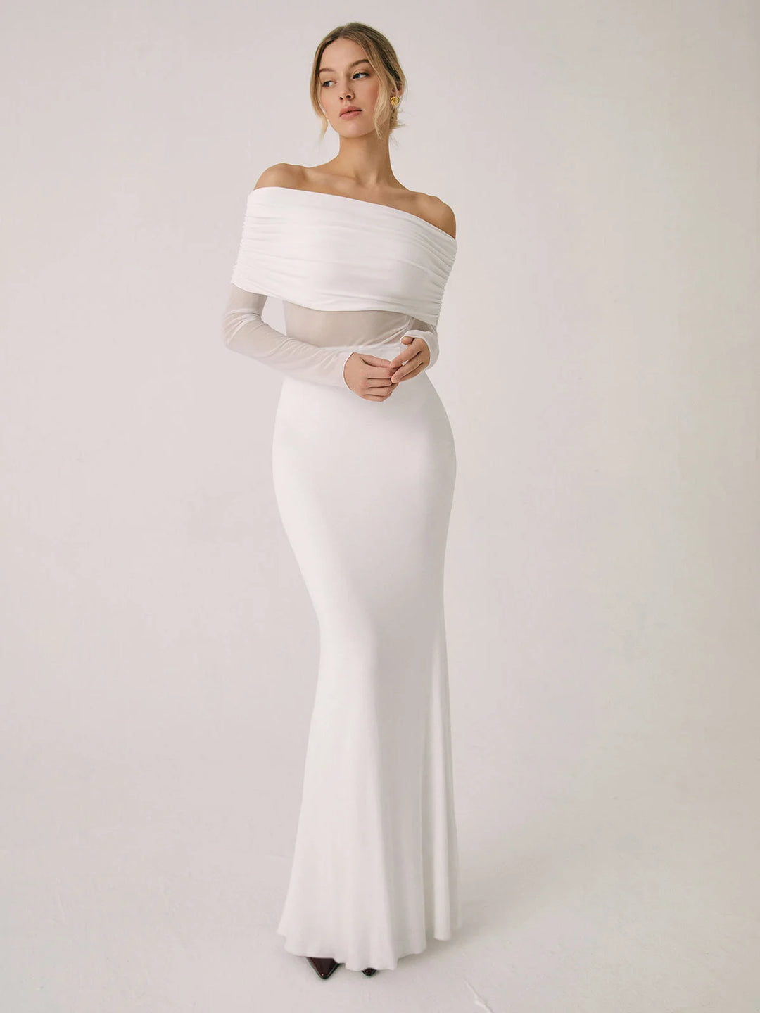 White off-shoulder dress with mesh sleeves, fitted silhouette.